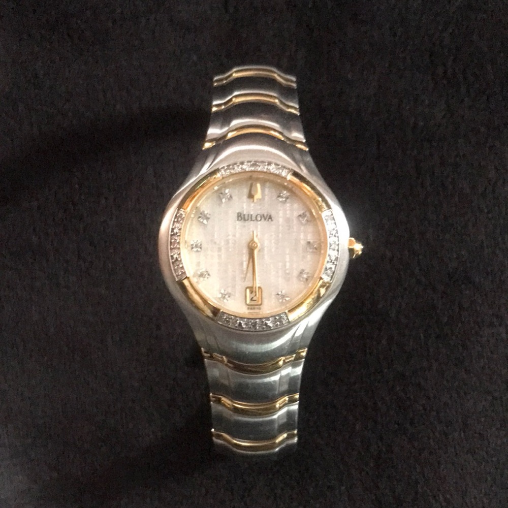 Bulova watch. Has 4 links to fit. Tells date. Diamond chips in and out.